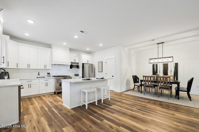 189 Craven Ct, Calabash, NC 28467 - kitchen featuring appliances with stainless steel finishes, custom range hood, white cabinetry, a kitchen island, and dark wood-style floors