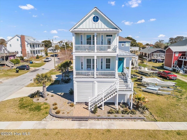 209 S 11th St, Morehead City, NC 28557 - coastal inspired home with covered porch, board and batten siding, a residential view, stairway, and metal roof