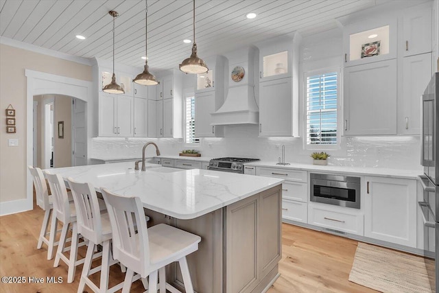 209 S 11th St, Morehead City, NC 28557 - kitchen featuring a sink, high end stainless steel range, an island with sink, light stone counters, and tasteful backsplash
