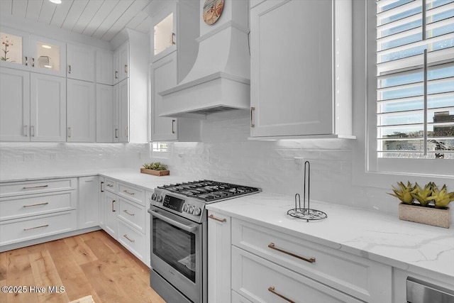 209 S 11th St, Morehead City, NC 28557 - kitchen with stainless steel range with gas cooktop, custom range hood, white cabinetry, glass insert cabinets, and wooden ceiling