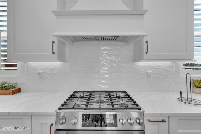 209 S 11th St, Morehead City, NC 28557 - kitchen featuring stainless steel range with gas stovetop, backsplash, white cabinetry, and premium range hood