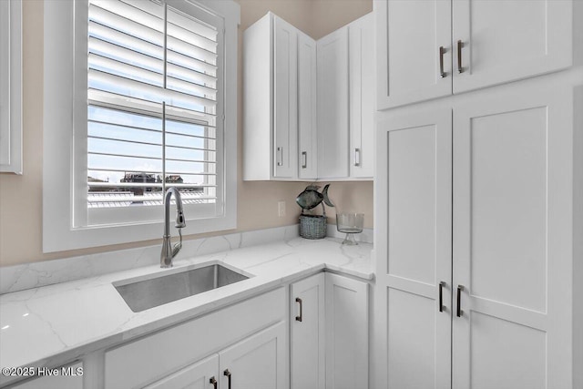 209 S 11th St, Morehead City, NC 28557 - kitchen featuring a sink, white cabinetry, and light stone countertops