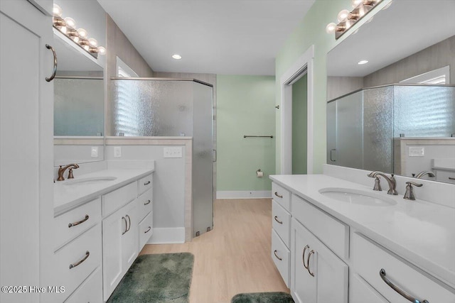 209 S 11th St, Morehead City, NC 28557 - full bath featuring two vanities, a stall shower, wood finished floors, and baseboards