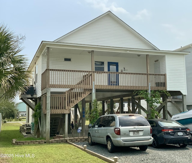 108 W Dolphin Dr, Oak Island, NC 28465 - beach home featuring stairway, a carport, covered porch, a front lawn, and driveway