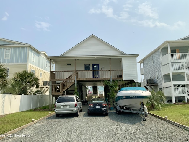 108 W Dolphin Dr, Oak Island, NC 28465 - coastal home with stairway, a carport, driveway, and a porch