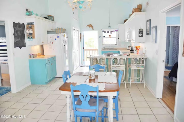 108 W Dolphin Dr, Oak Island, NC 28465 - dining space featuring light tile patterned floors, a towering ceiling, a chandelier, and baseboards