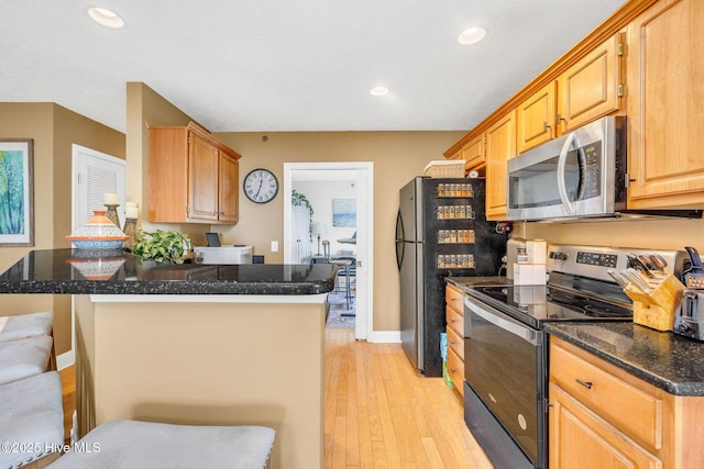 208 Carolina Beach Ave S Unit 202, Carolina Beach, NC 28428 - kitchen with stainless steel appliances, light wood-type flooring, a peninsula, baseboards, and recessed lighting