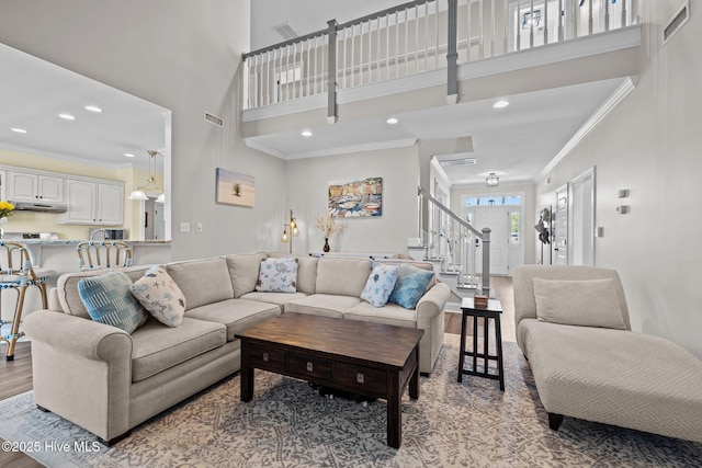 110 Gemini Dr, Cape Carteret, NC 28584 - living room featuring crown molding, light wood finished floors, stairs, a high ceiling, and recessed lighting