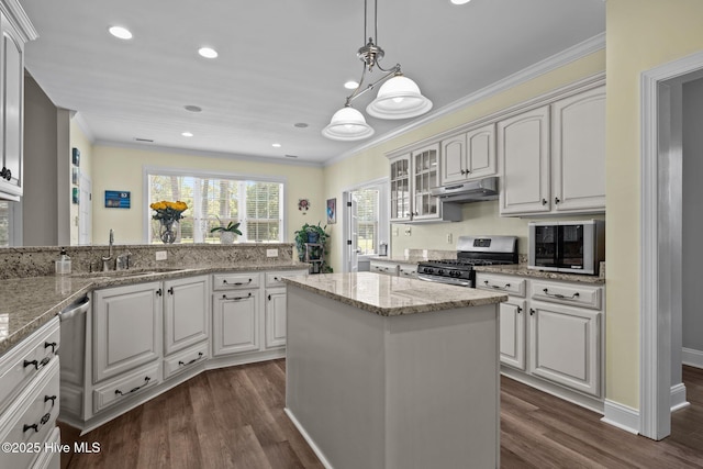 110 Gemini Dr, Cape Carteret, NC 28584 - kitchen with stainless steel gas stove, under cabinet range hood, ornamental molding, dark wood-type flooring, and glass insert cabinets
