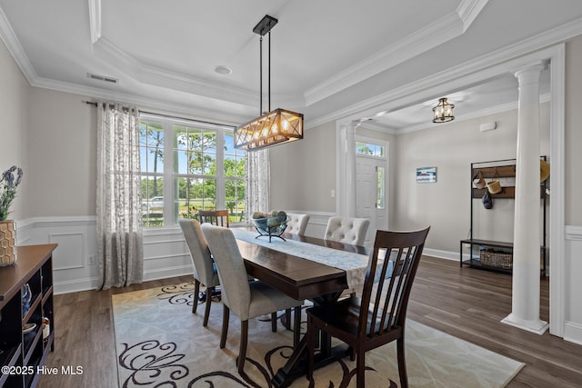 110 Gemini Dr, Cape Carteret, NC 28584 - dining space featuring ornate columns, wood finished floors, a raised ceiling, a chandelier, and a wainscoted wall