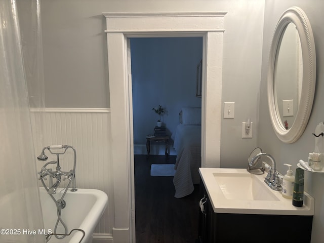 314 Ave B, New Bern, NC 28560 - full bath featuring a tub to relax in, vanity, a wainscoted wall, and wood finished floors
