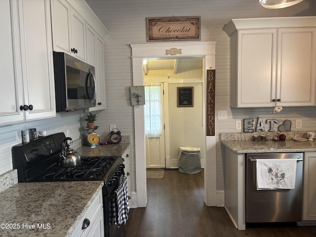 314 Ave B, New Bern, NC 28560 - kitchen with appliances with stainless steel finishes, white cabinetry, dark wood finished floors, and light stone countertops