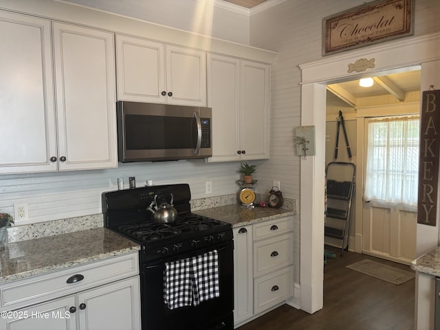 314 Ave B, New Bern, NC 28560 - kitchen with stainless steel microwave, black gas range oven, white cabinets, dark wood-style flooring, and crown molding