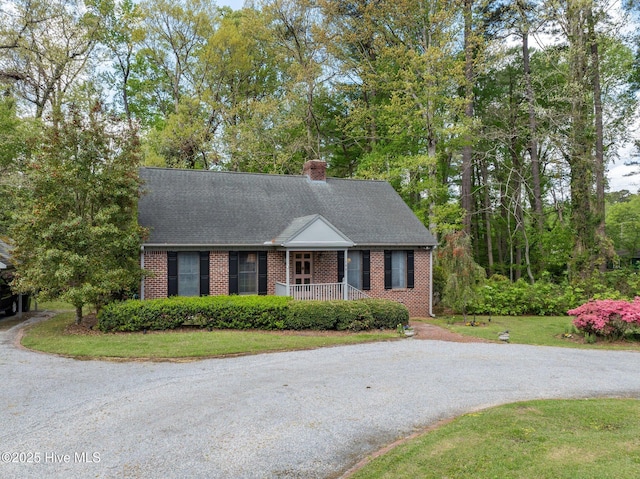 103 Camelia Dr, Washington, NC 27889 - view of front facade featuring brick siding, covered porch, a chimney, and a shingled roof
