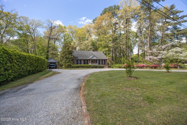 103 Camelia Dr, Washington, NC 27889 - view of front of house with curved driveway, a front lawn, a chimney, and a carport