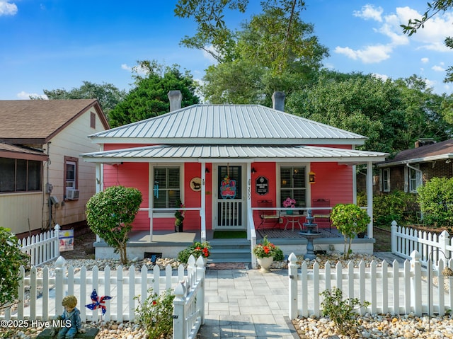 209 W St George St, Southport, NC 28461 - bungalow with a porch, a fenced front yard, metal roof, and cooling unit
