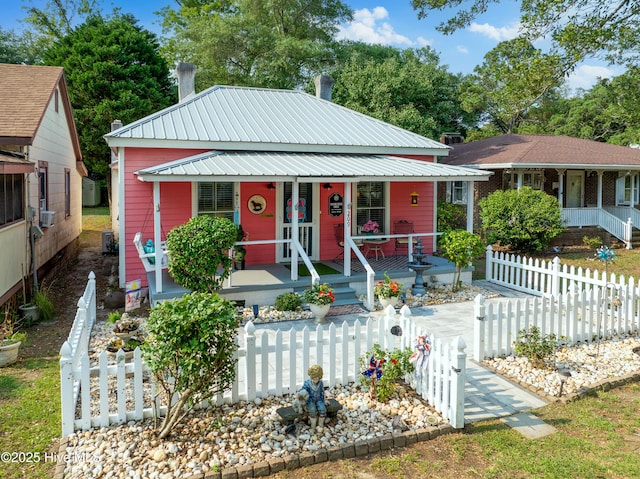 209 W St George St, Southport, NC 28461 - view of front facade with a porch, metal roof, and a fenced front yard