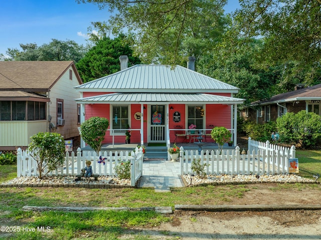 209 W St George St, Southport, NC 28461 - bungalow-style home featuring covered porch, a fenced front yard, and metal roof