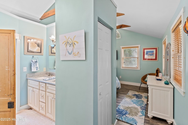 209 W St George St, Southport, NC 28461 - ensuite bathroom with lofted ceiling, double vanity, wood finished floors, and baseboards