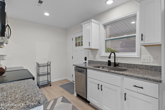 5302 Autumn Dr, Wilmington, NC 28409 - kitchen with appliances with stainless steel finishes, a sink, light wood-type flooring, white cabinets, and dark stone counters