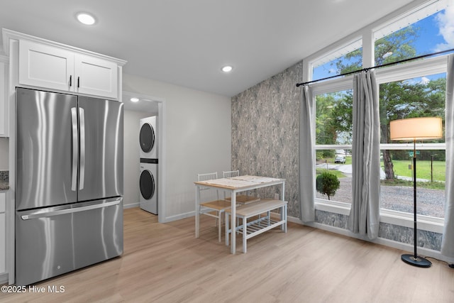5302 Autumn Dr, Wilmington, NC 28409 - kitchen with freestanding refrigerator, stacked washer / drying machine, light wood finished floors, white cabinetry, and baseboards
