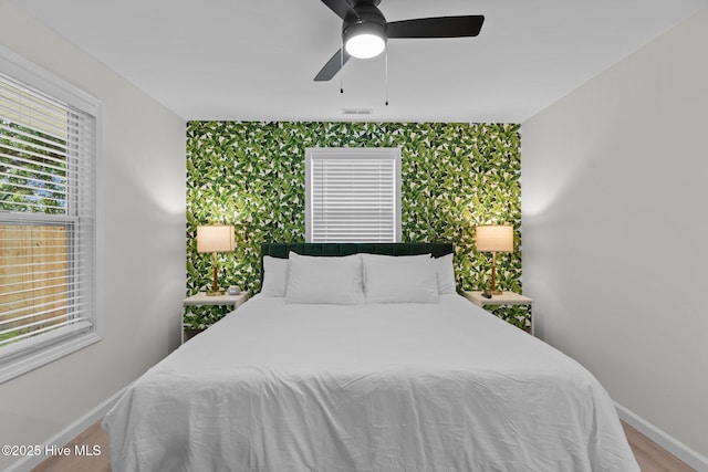 5302 Autumn Dr, Wilmington, NC 28409 - bedroom with baseboards, an accent wall, wallpapered walls, and wood finished floors