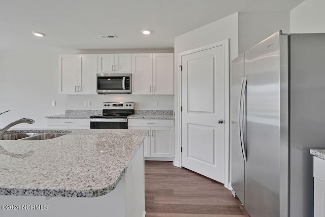 246 Kite Cir NE Lot 667, Bolivia, NC 28422 - kitchen featuring stainless steel appliances, a sink, white cabinets, dark wood-style flooring, and light stone counters
