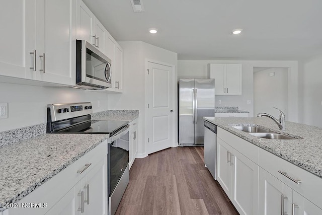 246 Kite Cir NE Lot 667, Bolivia, NC 28422 - kitchen featuring stainless steel appliances, a sink, white cabinetry, dark wood-type flooring, and light stone countertops
