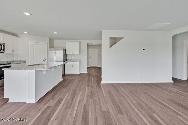 246 Kite Cir NE Lot 667, Bolivia, NC 28422 - kitchen with stainless steel appliances, light wood-style floors, white cabinetry, light stone counters, and recessed lighting