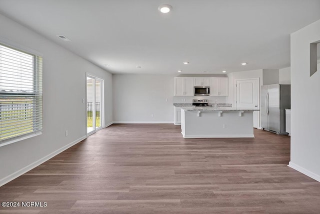 246 Kite Cir NE Lot 667, Bolivia, NC 28422 - kitchen featuring stainless steel appliances, white cabinetry, a kitchen breakfast bar, recessed lighting, and wood finished floors