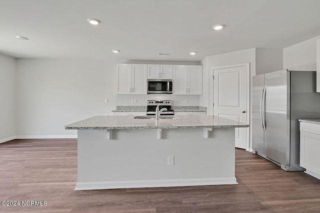 246 Kite Cir NE Lot 667, Bolivia, NC 28422 - kitchen featuring appliances with stainless steel finishes, a sink, a breakfast bar, light stone countertops, and white cabinetry