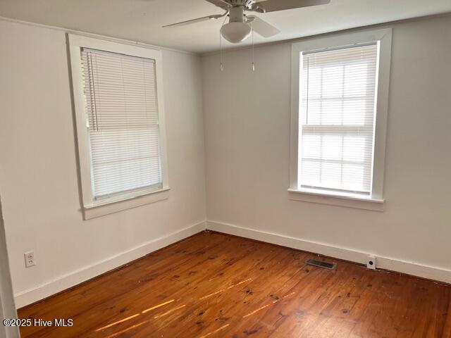 3356 Howard Ave, Tarboro, NC 27886 - spare room with wood-type flooring, a ceiling fan, baseboards, and healthy amount of natural light