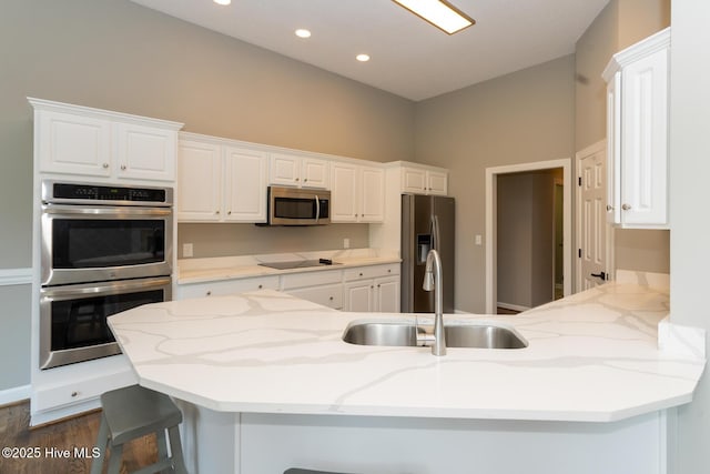 24 Mcnish Rd, Southern Pines, NC 28387 - kitchen featuring appliances with stainless steel finishes, a sink, a peninsula, a breakfast bar, and white cabinets