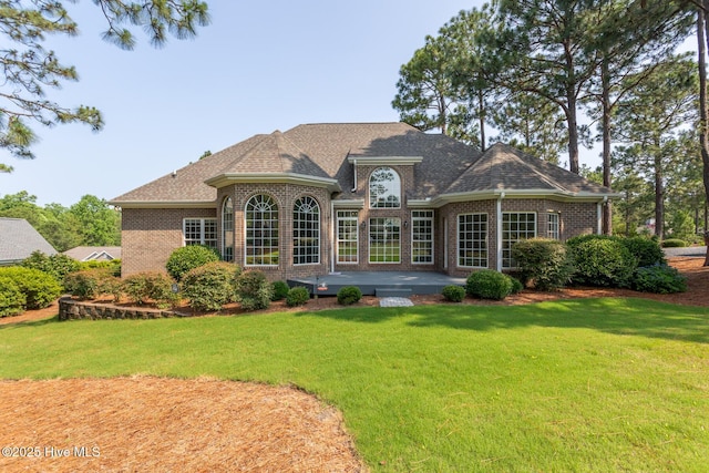 24 Mcnish Rd, Southern Pines, NC 28387 - rear view of property featuring a patio area, brick siding, a lawn, and a shingled roof