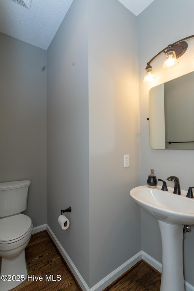 24 Mcnish Rd, Southern Pines, NC 28387 - bathroom featuring wood finished floors, toilet, and baseboards
