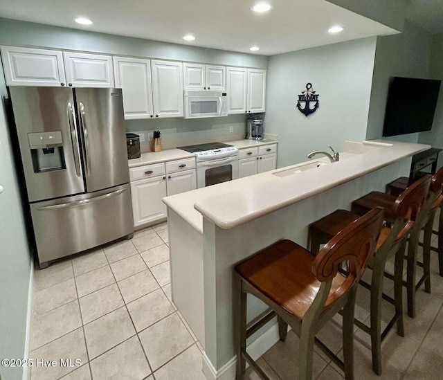 104 S 3rd St Unit H2, Morehead City, NC 28557 - kitchen with white appliances, a sink, a kitchen breakfast bar, white cabinetry, and recessed lighting