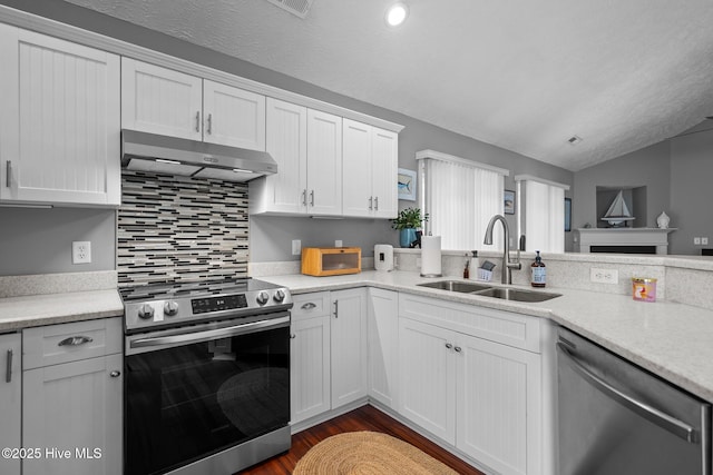 8122 Bahia Honda Dr, Wilmington, NC 28412 - kitchen featuring appliances with stainless steel finishes, under cabinet range hood, a sink, vaulted ceiling, and white cabinets