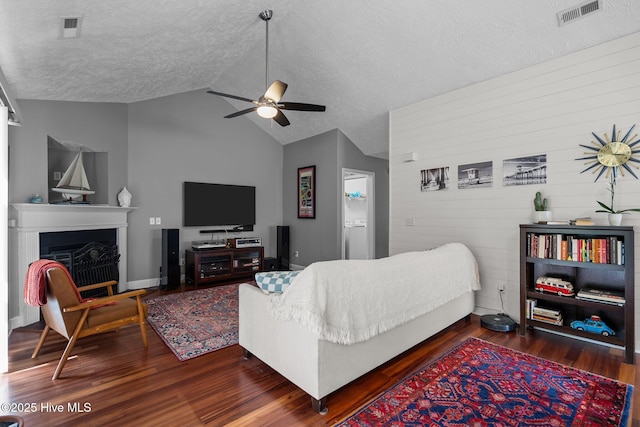 8122 Bahia Honda Dr, Wilmington, NC 28412 - living room with ceiling fan, wood finished floors, a textured ceiling, wooden walls, and a fireplace
