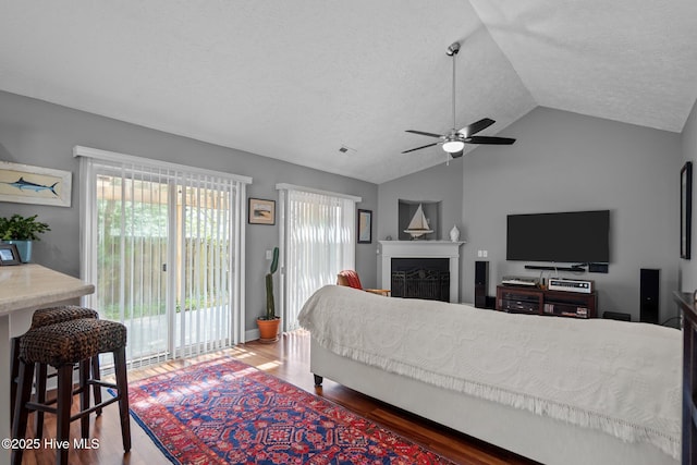 8122 Bahia Honda Dr, Wilmington, NC 28412 - living area featuring ceiling fan, lofted ceiling, wood finished floors, a textured ceiling, and a fireplace