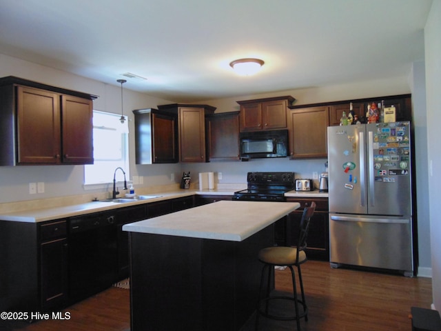 205 Brice Ct, Hubert, NC 28539 - kitchen featuring black appliances, a sink, light countertops, dark wood-style flooring, and hanging light fixtures