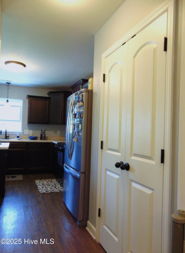 205 Brice Ct, Hubert, NC 28539 - kitchen featuring freestanding refrigerator, dark wood-type flooring, light countertops, dark brown cabinetry, and range
