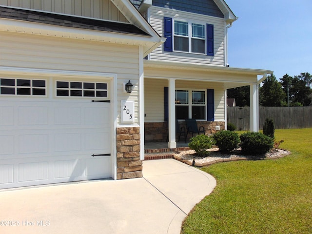 205 Brice Ct, Hubert, NC 28539 - view of front of property with covered porch, a garage, stone siding, driveway, and board and batten siding