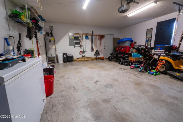 306 Top Knot Rd, Hubert, NC 28539 - garage featuring electric water heater, a garage door opener, washer / dryer, and white refrigerator
