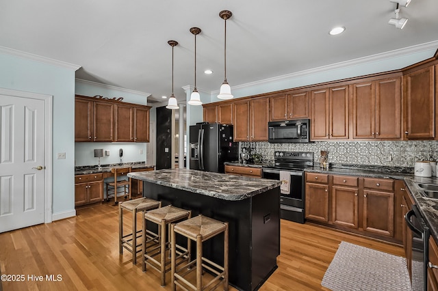 4301 Gainesford Ct, Wilmington, NC 28412 - kitchen with black appliances, ornamental molding, a center island, a breakfast bar area, and decorative backsplash