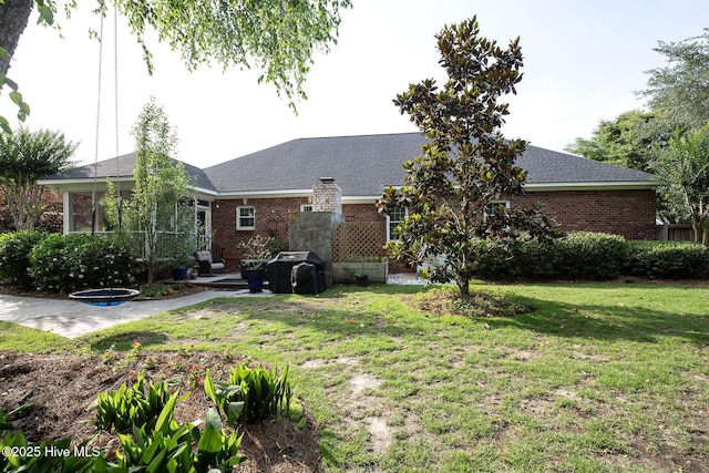 4301 Gainesford Ct, Wilmington, NC 28412 - view of front facade with a sunroom, brick siding, a front lawn, and a patio area