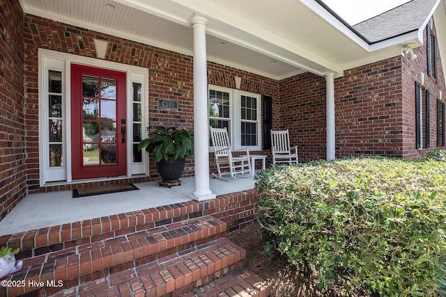 4301 Gainesford Ct, Wilmington, NC 28412 - view of exterior entry featuring covered porch, brick siding, and a shingled roof