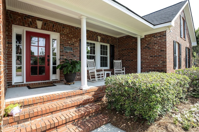 4301 Gainesford Ct, Wilmington, NC 28412 - entrance to property with a porch, a shingled roof, and brick siding