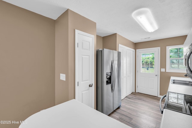 711 Navaho Trl, Wilmington, NC 28409 - kitchen with stainless steel fridge, light wood-type flooring, light countertops, and electric range