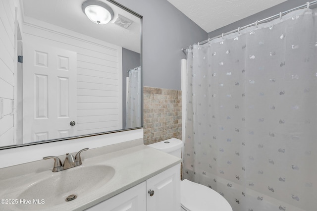 711 Navaho Trl, Wilmington, NC 28409 - bathroom with tile walls, vanity, curtained shower, wainscoting, and a textured ceiling