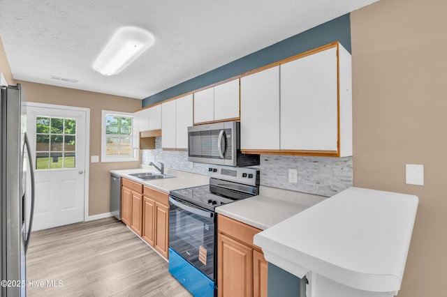 711 Navaho Trl, Wilmington, NC 28409 - kitchen featuring appliances with stainless steel finishes, light wood-style flooring, light countertops, and decorative backsplash